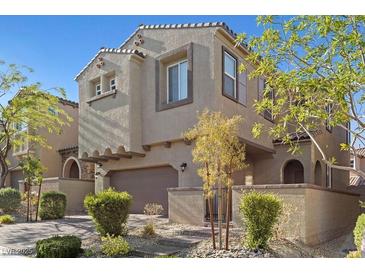 Charming two-story home featuring a stucco exterior, tile roof, manicured landscaping, and attached two-car garage at 10468 Skye Knoll Ave, Las Vegas, NV 89166