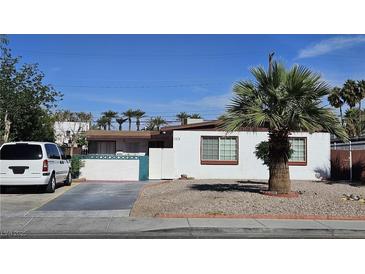 Modest single-story home showcasing desert landscaping, white exterior, and a quaint, gated front yard at 1414 Rexford Pl, Las Vegas, NV 89104