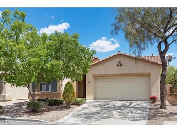 Charming single-story home with a well-maintained lawn and mature trees, featuring a two-car garage and neutral tones at 1524 Remembrance Hill St, Las Vegas, NV 89144