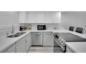 Bright kitchen featuring white cabinets, stainless steel appliances, and a modern countertop at 2080 Karen Ave # 1, Las Vegas, NV 89169