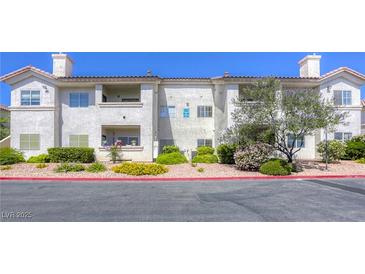 Well-maintained condo building with lush landscaping and a vibrant red rock ground covering at 2117 Echo Bay St # 102, Las Vegas, NV 89128