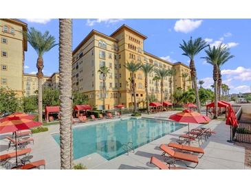 Resort-style pool with ample lounge chairs and red umbrellas at 2455 W Serene Ave # 923, Las Vegas, NV 89123