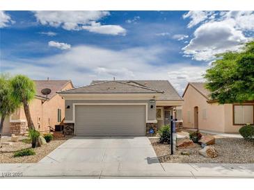 Charming single-story home featuring a two-car garage and desert landscaping with rock accents at 2621 Ground Robin Dr, North Las Vegas, NV 89084