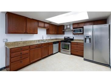 Traditional kitchen featuring stainless steel appliances, wooden cabinets, and tile flooring at 3719 Centennial Cir, Las Vegas, NV 89121