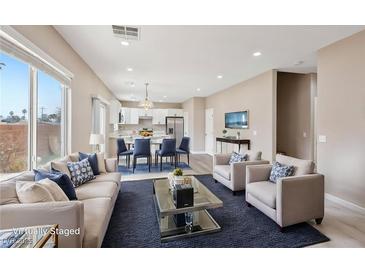 Bright open living space with large windows, modern furniture and adjoined to the dining area and kitchen at 5286 Monterey Park Cir, Las Vegas, NV 89146