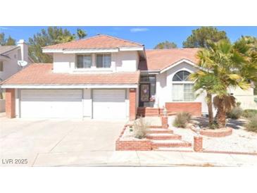 Charming two-story home with a two-car garage, red-tiled roof, brick-trim and landscaped front yard at 9704 Falling Star Ave, Las Vegas, NV 89117