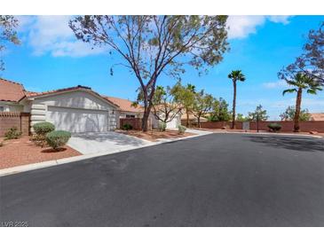 Charming single-story home with a well-maintained yard and a two-car garage on a sunny day at 9962 Catalina Canyon Ave, Las Vegas, NV 89147