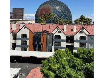 View of condominiums with palm trees and covered parking in a vibrant community at 210 E Flamingo Rd # 419, Las Vegas, NV 89169