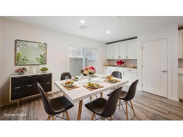 Bright dining area features modern table setting, sliding glass doors, and stylish decor at 376 Yellow Finch Ln, Henderson, NV 89012