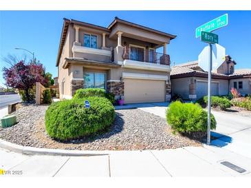 Charming two-story home with a balcony, stone accents, and well-maintained landscaping at 7609 Rory Ct, Las Vegas, NV 89129