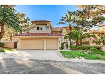 Inviting two-story home featuring a red tile roof, mature landscaping and a spacious driveway leading to a two-car garage at 8051 Castle Pines Ave, Las Vegas, NV 89113