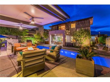 Inviting backyard oasis with a pool, hot tub, fire pit, and covered patio seating, perfect for outdoor entertaining at 10313 Jade Point Dr, Las Vegas, NV 89135