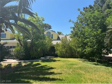 Charming yellow two-story home with mature trees and large front yard at 1385 Ringe Ln, Las Vegas, NV 89110