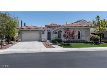 Charming single-story home featuring a tile roof, neutral stucco, arched entry, and well-manicured landscaping at 2080 Orchard Mist St, Las Vegas, NV 89135