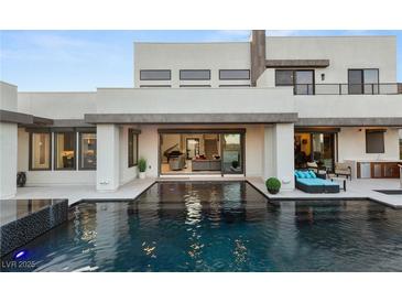Stunning backyard pool area with modern lounge furniture, perfect for relaxation and entertainment at 4024 Desert Trace Ct, Las Vegas, NV 89129