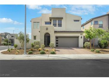 Two story home with modern design, desert landscaping and a gray garage door at 513 Monarch Ridge Ct, North Las Vegas, NV 89084