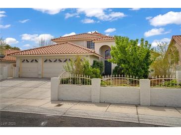 Charming single-Gathering home featuring a well-manicured front yard, a three-car garage, and a red tile roof at 5609 Red Bluff Dr, Las Vegas, NV 89130