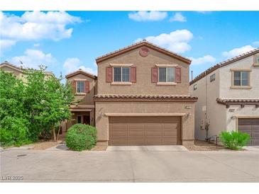Charming two-story home with a two-car garage and desert landscaping under a bright blue, partly cloudy sky at 9024 Hazy Haven Ct, Las Vegas, NV 89149