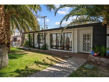 Charming single-story home featuring black trim, white exterior, manicured lawn, and mature landscaping at 1004 Yucca Ave, Las Vegas, NV 89104
