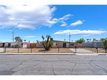 Charming single-story home with desert landscaping, secured by a wrought iron fence at 1615 Palora Ave, Las Vegas, NV 89169