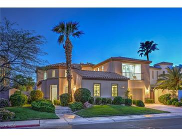 Elegant home exterior features a charming balcony, lush landscaping, and a well-manicured lawn at 2571 Red Springs Dr, Las Vegas, NV 89135