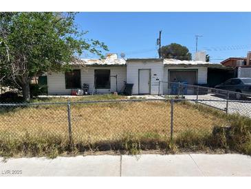 Modest single story home with a chain link fence and a lawn in need of care at 3072 Greendale St, Las Vegas, NV 89121