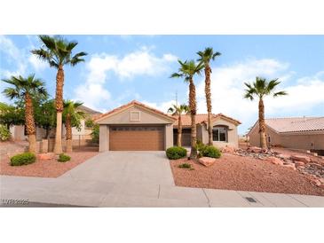 Charming single-story home featuring a two-car garage and desert landscaping with mature palm trees at 3157 Faiss Dr, Las Vegas, NV 89134