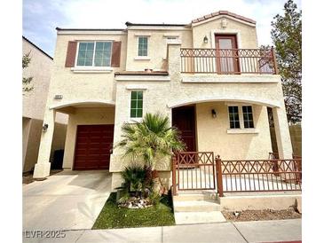 Inviting two-story home featuring a charming balcony, a two-car garage, and desert landscaping at 10372 Beautiful Fruit St, Las Vegas, NV 89183
