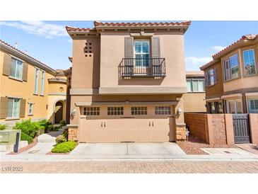 Inviting tan two-story home with a two-car garage and charming balcony on a sunny day at 11294 Corsica Mist Ave, Las Vegas, NV 89135