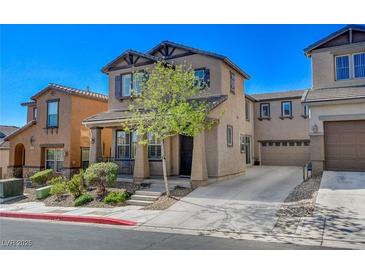 Charming two-story stucco home with a landscaped front yard and a spacious driveway on a sunny day at 165 Calm Morning Ave, Henderson, NV 89002