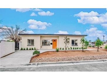 Inviting single-story home with an orange front door, easy care landscape, and fresh exterior paint at 5013 Vermont Ave, Las Vegas, NV 89107