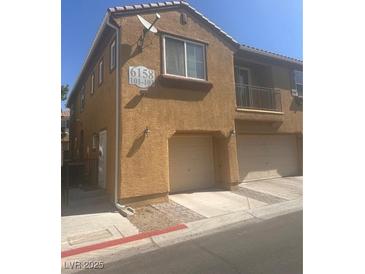 Tan two-story home featuring an attached garage, and a small upper balcony at 6158 Calm Breeze Ave # 101, Las Vegas, NV 89108