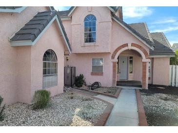 Charming two-story home with a unique archway entrance and a well-maintained front yard landscape at 6561 Avon Ct, Las Vegas, NV 89108