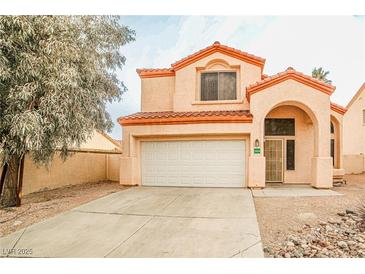 Charming two-story home featuring a two-car garage and well-maintained landscaping with desert-style rock accents at 1604 Tamborine Ct, Las Vegas, NV 89128