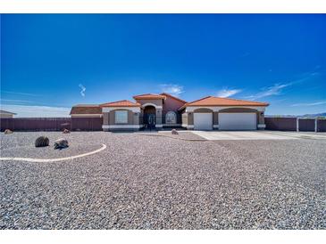 Charming home featuring a tile roof, desert landscaping, and an attached three car garage at 2171 Deadwood St, Pahrump, NV 89048