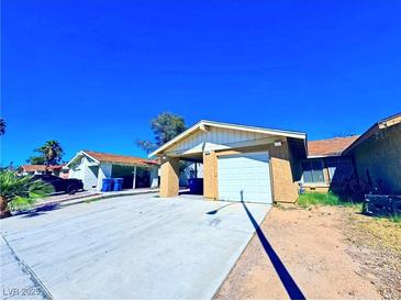 Charming single-story home featuring an attached garage and well-lit driveway at 4016 Calle Paula, Las Vegas, NV 89103