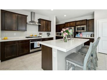 This spacious kitchen features dark wood cabinetry, white countertops, and a stainless steel oven and range hood at 4630 Adonis Blue St, North Las Vegas, NV 89031