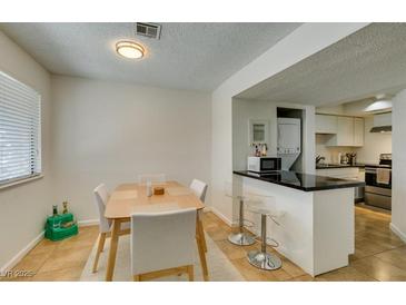 Charming dining area adjacent to the kitchen, featuring a modern table with seating for four at 5725 Smoke Ranch Rd # A, Las Vegas, NV 89108