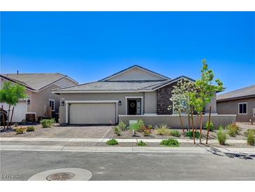 Charming single-story home showcasing desert landscaping, stone accents, and a brick driveway at 689 Moonstone Beach Pl, Henderson, NV 89011
