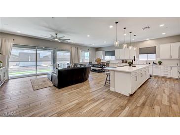 Open concept living room and kitchen featuring modern decor and a seamless transition to the outdoor patio at 689 Moonstone Beach Pl, Henderson, NV 89011