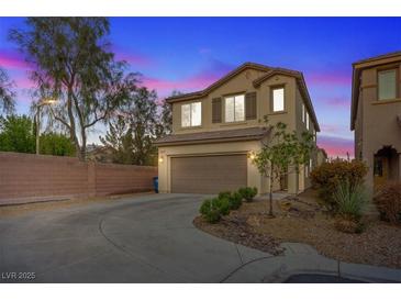 Two-story home with a two-car garage, desert landscaping and a brick wall in the front yard at 8566 Burning Bridge Ct, Las Vegas, NV 89131