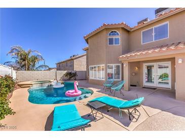 Inviting backyard oasis featuring a sparkling pool, lounge chairs, and a lush garden, perfect for relaxation and entertainment at 9124 Sapphire Ridge Ave, Las Vegas, NV 89129