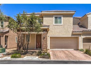 Inviting two-story home with a two-car garage and stone accents on the facade and well-manicured landscaping at 9326 Noble Sage Ave, Las Vegas, NV 89148