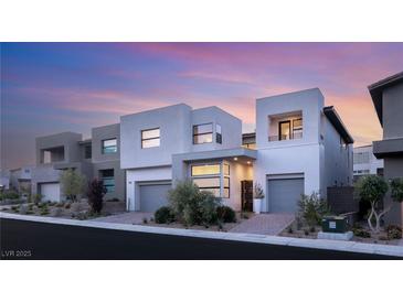 Contemporary home exterior showcasing clean lines, neutral color palette, and well-manicured landscaping under a beautiful sunset sky at 10752 Patina Hills Ct, Las Vegas, NV 89135