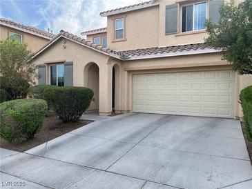 Charming two-story home featuring neutral paint, archway entry, 2-car garage, and manicured shrubbery at 5653 Nobleton Ct, North Las Vegas, NV 89081