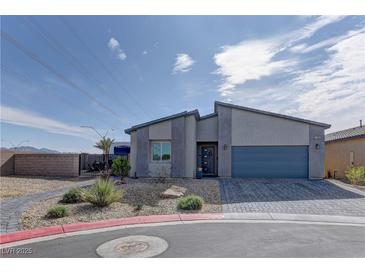 Contemporary home showing a modern desert landscape and concrete paved driveway to the attached garage at 7938 Jessamy St, North Las Vegas, NV 89084