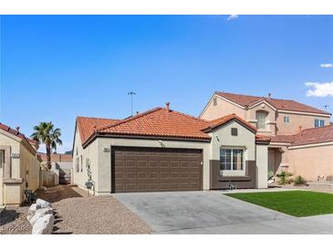 Charming single-story home featuring desert landscaping, a tile roof, and an attached two-car garage at 7957 Lovely Pine Pl, Las Vegas, NV 89143
