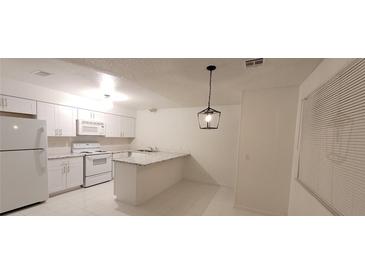 Bright kitchen featuring white cabinetry, granite counters, and modern appliances at 833 Hedge Way # 2, Las Vegas, NV 89110