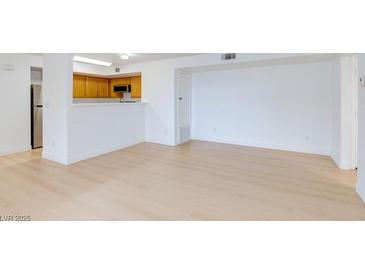 Bright living room with light colored wood flooring open to the kitchen at 8450 Alta Dr # 136, Las Vegas, NV 89145
