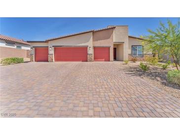 Charming single-story home featuring a three-car garage and brick-paved driveway at 10266 Sweet Holly Pl, Las Vegas, NV 89149